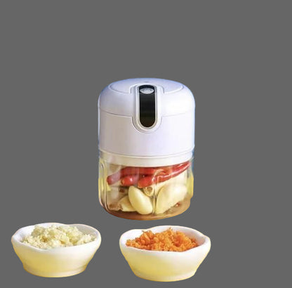 Handheld food chopper with chopped ingredients on a yellow table against a blue background